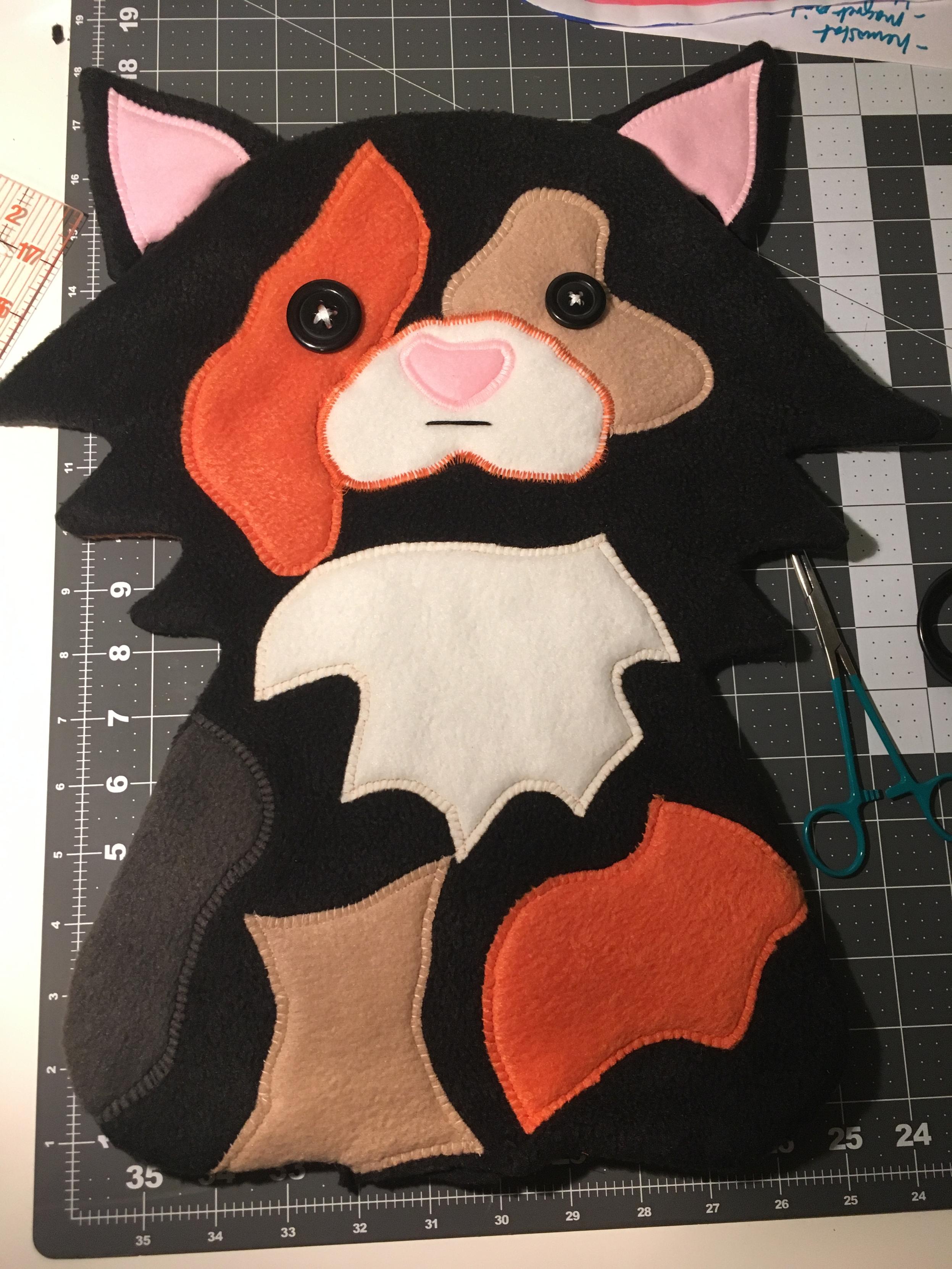 Plushie of a calico cat.